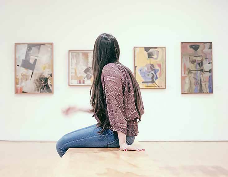 betvictro伟德体育一个女人在看墙上的几件艺术品的照片