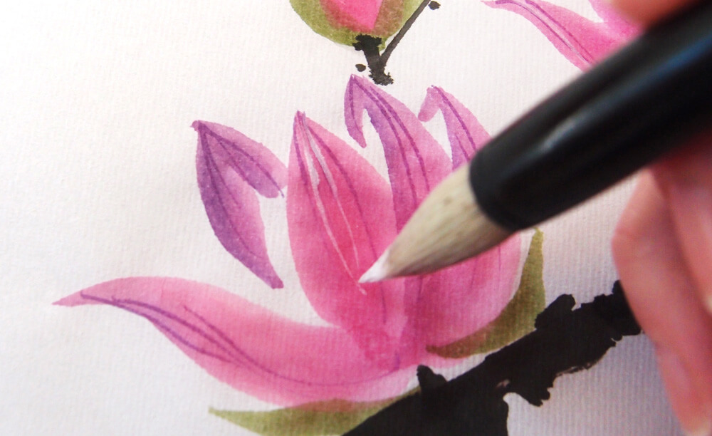 betvictro伟德体育用画笔蘸上白色水粉，在白玉兰花上画出细腻的纹理