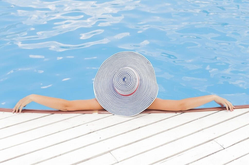 betvictro伟德体育戴白帽的女子在泳池里放松